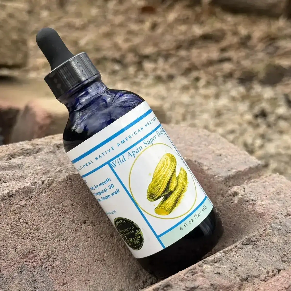 Apán supplement bottles arranged on rocks in a natural outdoor setting