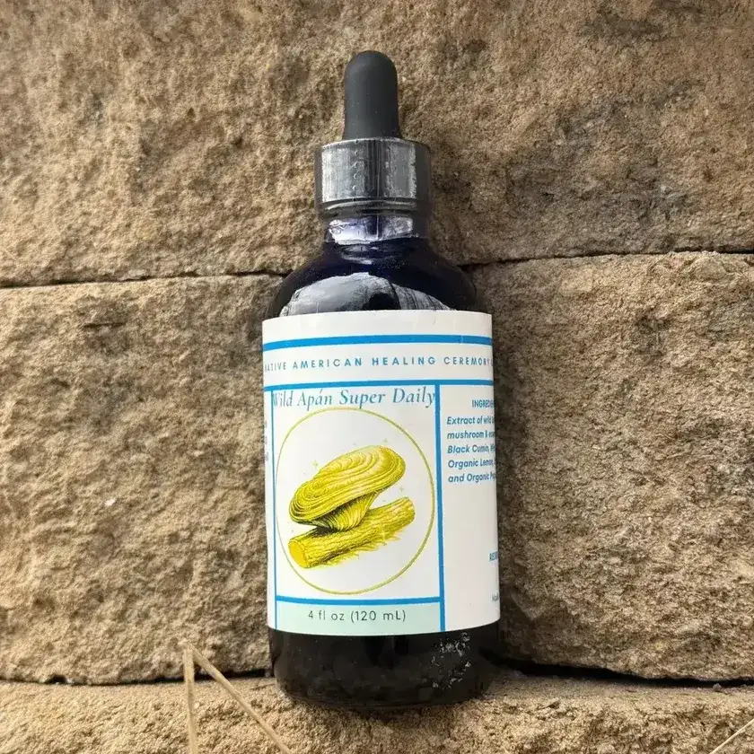 Apán Super Daily botanical supplement bottle on a stone